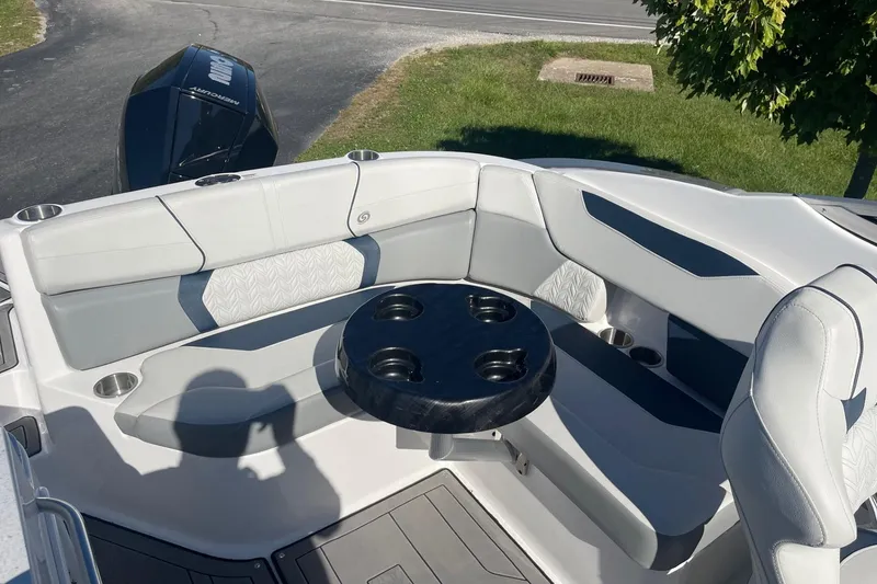 Slide: The Image of 2023 Hurricane SunDeck 2400 OB boat interior with cushioned seating and round table. - 10