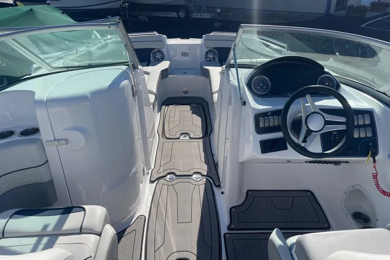 Slide: The Image of 2023 Hurricane SunDeck 2400 OB boat interior with steering wheel and seating area. - 14