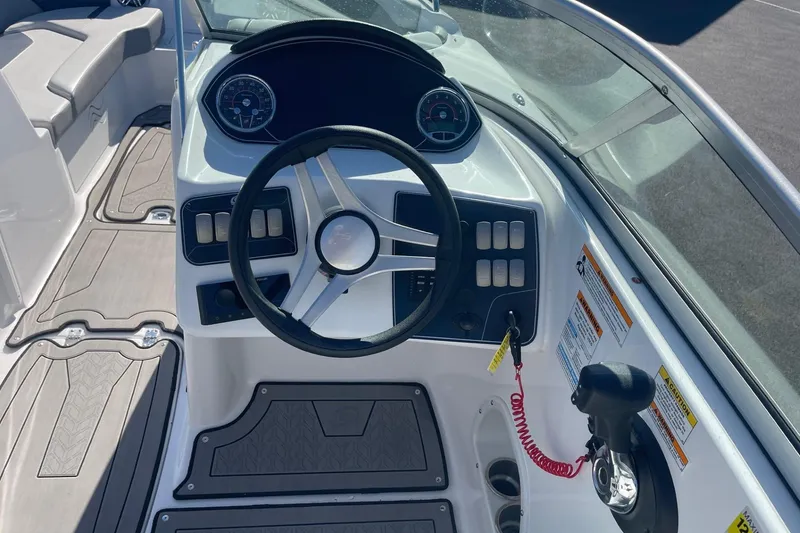 Slide: The Image of 2023 Hurricane SunDeck 2400 OB boat dashboard with steering wheel and controls. - 15