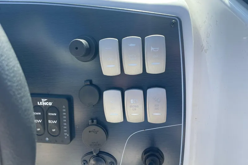 Slide: The Image of Control panel of 2023 Hurricane SunDeck 2400 OB boat with switches and buttons. - 18