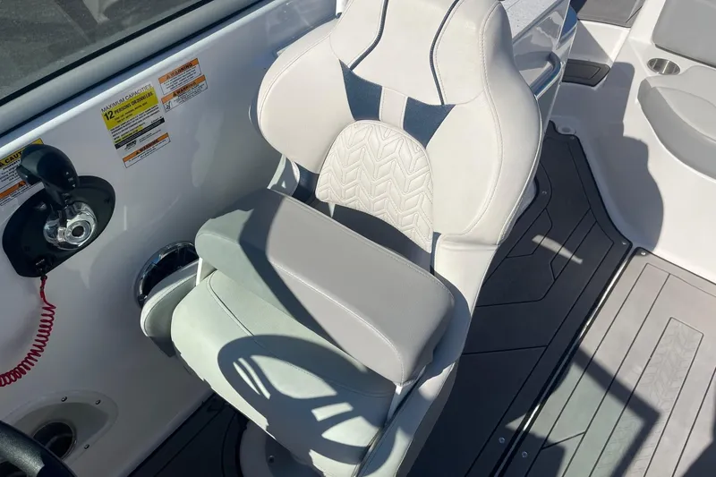 Slide: The Image of Captain's seat on 2023 Hurricane SunDeck 2400 OB boat, featuring ergonomic design and controls. - 20