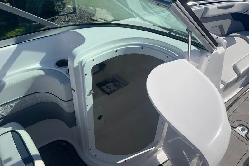 Slide: The Image of 2023 Hurricane SunDeck 2400 OB boat interior with open storage compartment and seating area. - 23