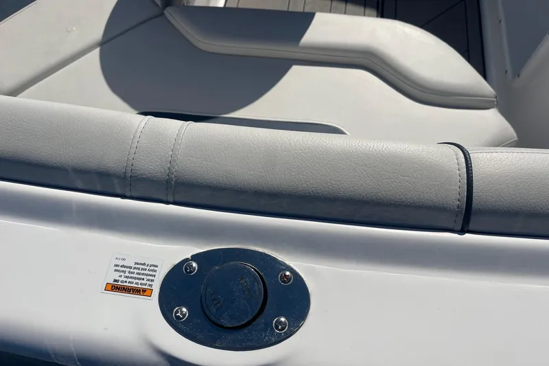 Slide: The Image of 2023 Hurricane SunDeck 2400 OB boat interior with cushioned seating and metal fixture. - 5