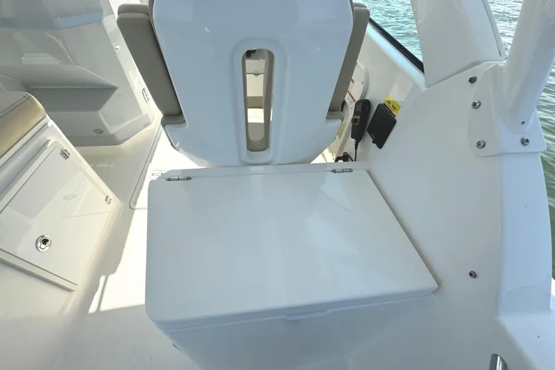 Slide: The Image of 2020 Pursuit DC 235 Dual Console boat on a serene lake with trees in the background. - 11