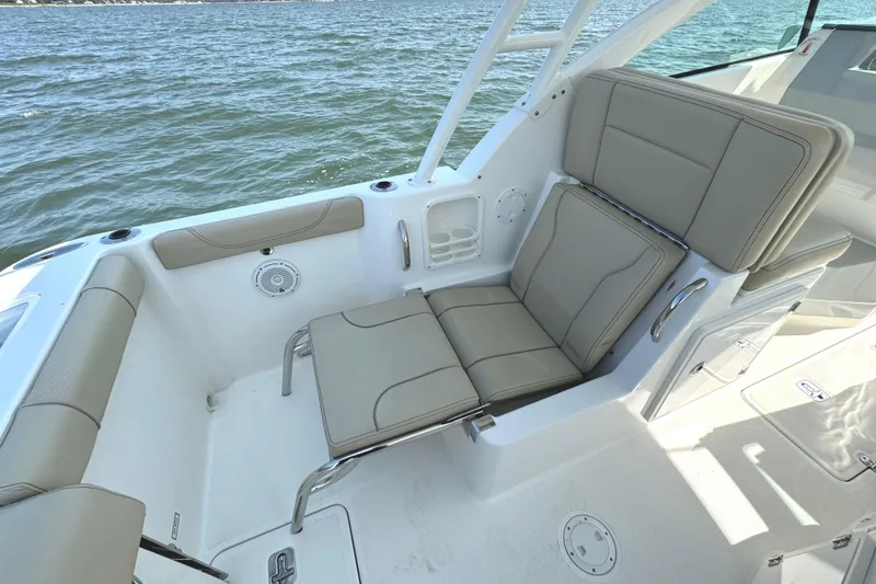 Slide: The Image of 2020 Pursuit DC 235 Dual Console boat deck with cushioned seating and cup holders. - 14