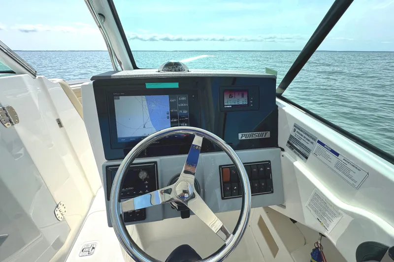 Slide: The Image of 2020 Pursuit DC 235 Dual Console boat storage compartments with open lids. - 20