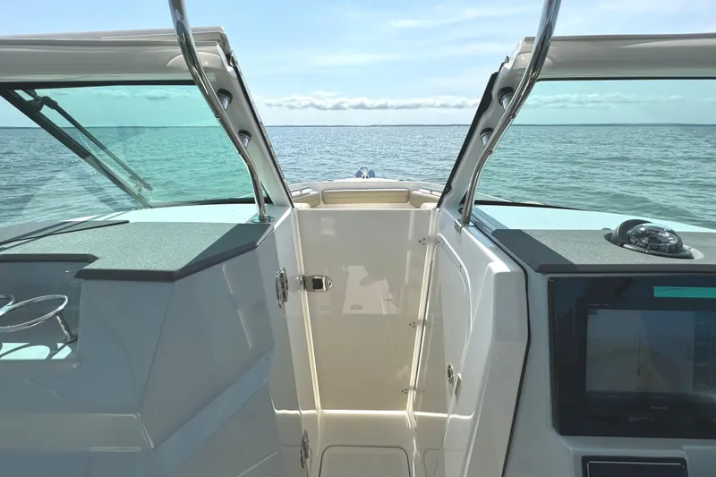 Slide: The Image of 2020 Pursuit DC 235 Dual Console boat interior with teak flooring and storage compartment. - 21