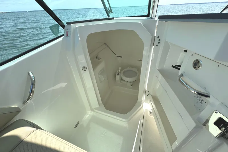 Slide: The Image of 2020 Pursuit DC 235 Dual Console boat interior bathroom with toilet and sink. - 26