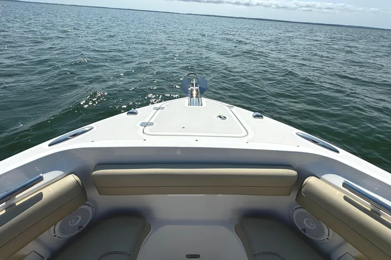 Slide: The Image of 2020 Pursuit DC 235 Dual Console boat with beige seating on open water. - 30