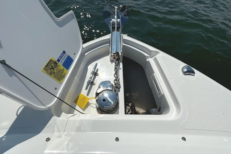 Slide: The Image of 2020 Pursuit DC 235 Dual Console boat on open water, showcasing bow and anchor. - 31