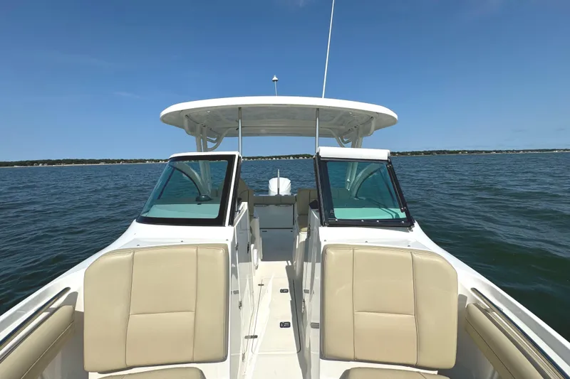 Slide: The Image of 2020 Pursuit DC 235 Dual Console boat interior with beige seating and compass design flooring. - 33