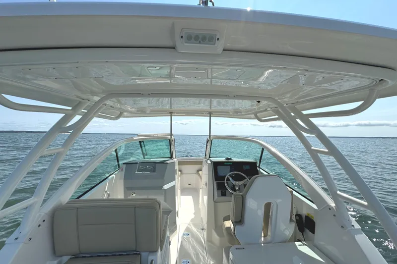 Slide: The Image of 2020 Pursuit DC 235 Dual Console boat on open water under clear blue sky. - 35