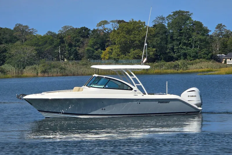 Slide: The Image of 2020 Pursuit DC 235 Dual Console boat cruising on a serene lake. - 4