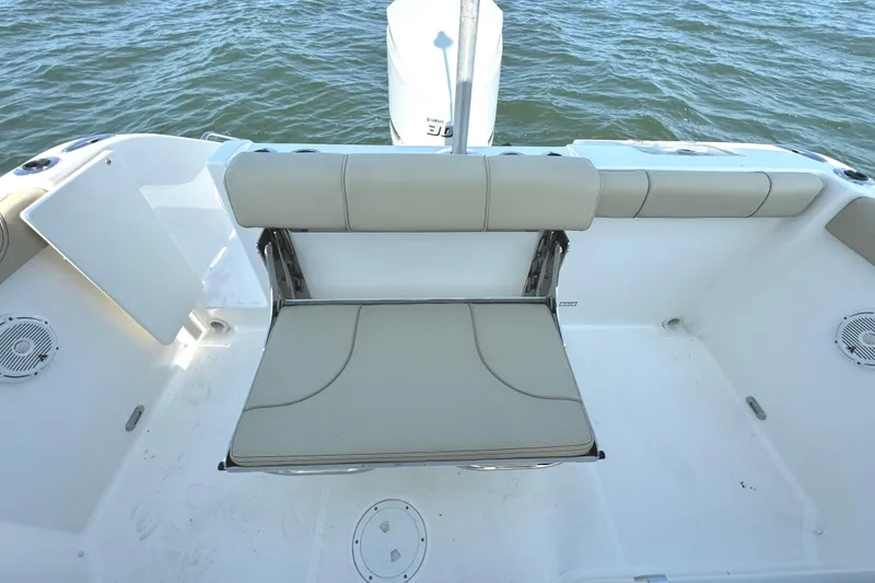 Slide: The Image of 2020 Pursuit DC 235 Dual Console boat on a serene lake with trees in the background. - 8