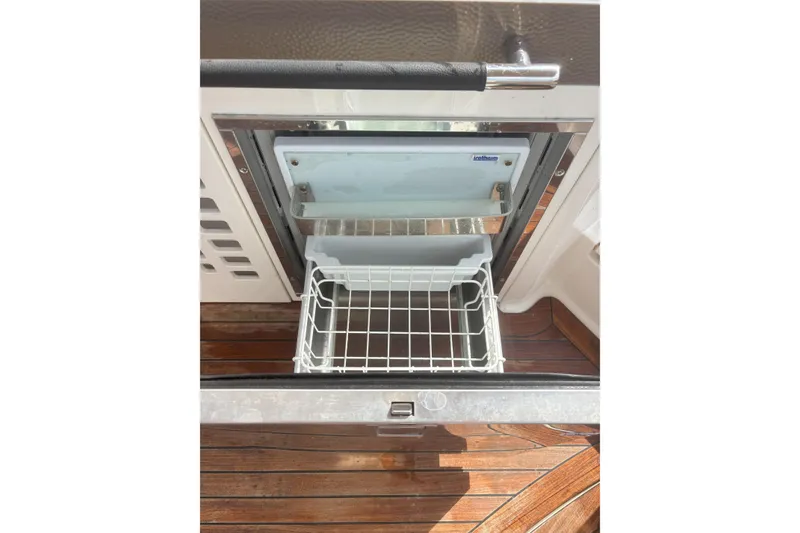 Slide: The Image of Open drawer refrigerator on 2016 Sea Ray 350 SLX boat, featuring wooden flooring. - 13