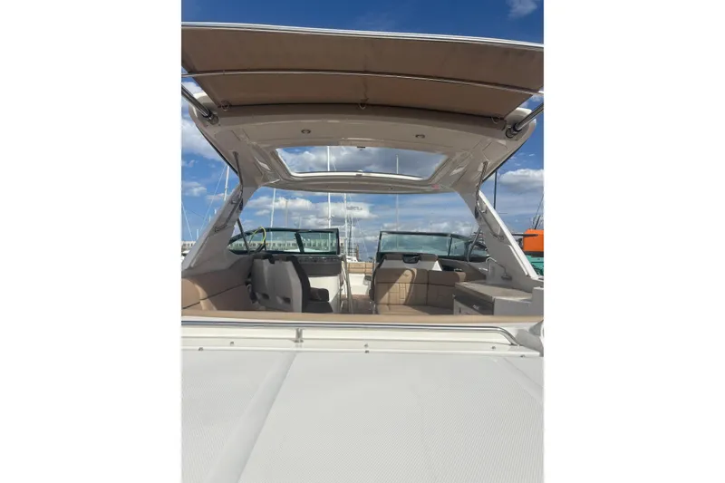 Slide: The Image of 2016 Sea Ray 350 SLX boat interior with open canopy under blue sky. - 16