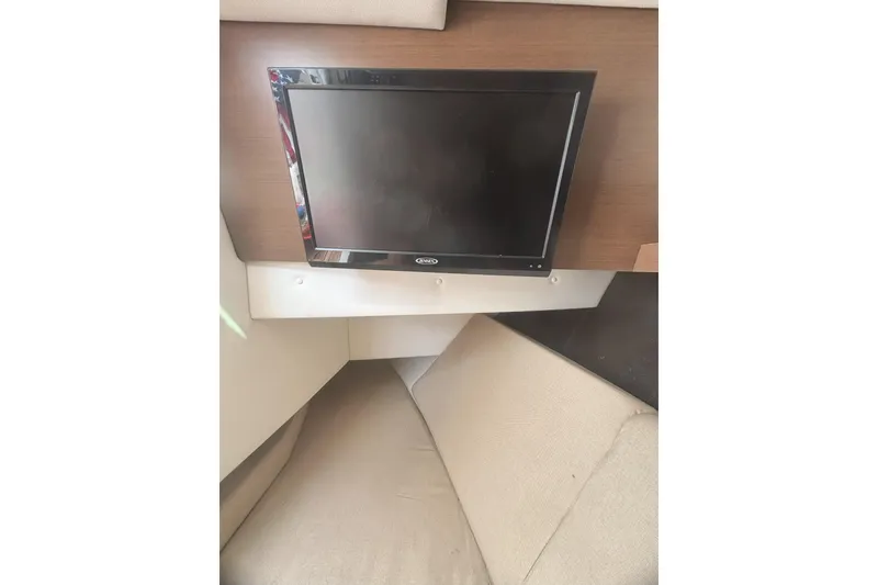 Slide: The Image of Interior of 2016 Sea Ray 350 SLX with wall-mounted TV and beige seating. - 23