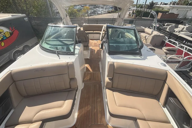 Slide: The Image of 2016 Sea Ray 350 SLX boat with tan seating and wooden deck, docked outdoors. - 7