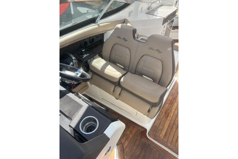 Slide: The Image of 2016 Sea Ray 350 SLX boat interior with dual beige seats and wooden flooring. - 8