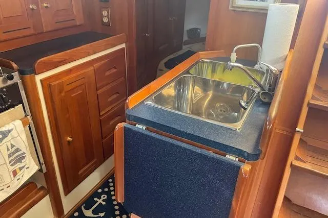 Slide: The Image of 2001 Tartan 3700 yacht kitchen with wooden cabinets and stainless steel sink. - 13