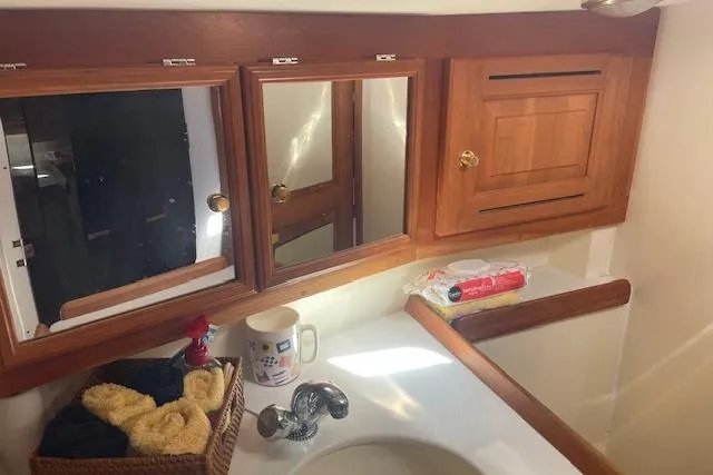 Slide: The Image of 2001 Tartan 3700 yacht bathroom with wooden cabinets and sink area. - 16