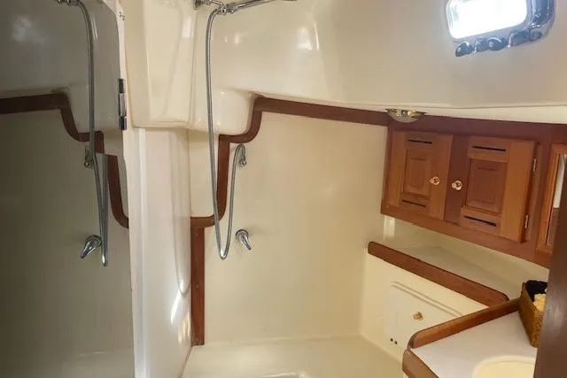 Slide: The Image of Tartan 3700 yacht bathroom interior, featuring wooden cabinets and a shower, 2001 model. - 17