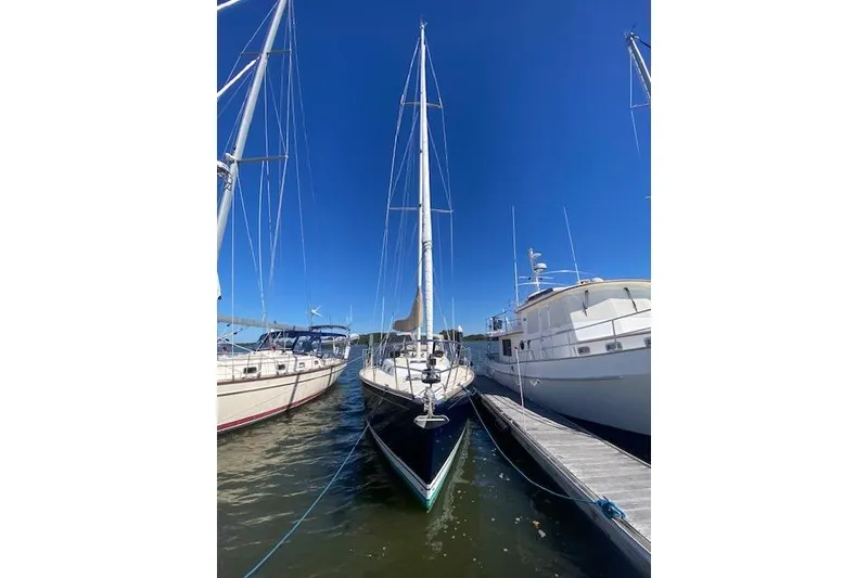 Slide: The Image of Sailboat Tartan 3700 (2001) docked between yachts under clear blue sky. - 28