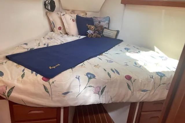 Slide: The Image of Cozy cabin bed in 2001 Tartan 3700 sailboat with floral bedding and plush toys. - 5