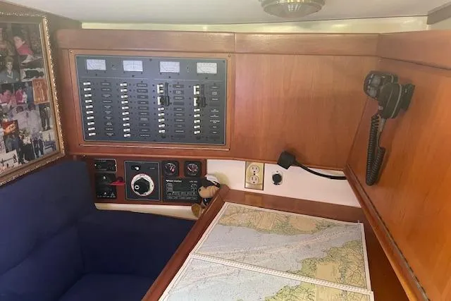 Slide: The Image of Navigation station in 2001 Tartan 3700 sailboat with control panel and nautical charts. - 9