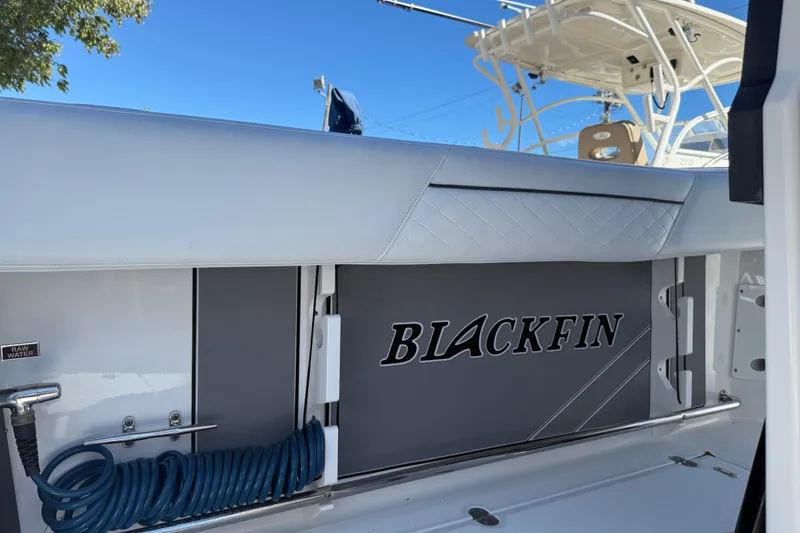 Slide: The Image of 2022 Blackfin 272 CC boat interior with raw water hose and storage compartment. - 14