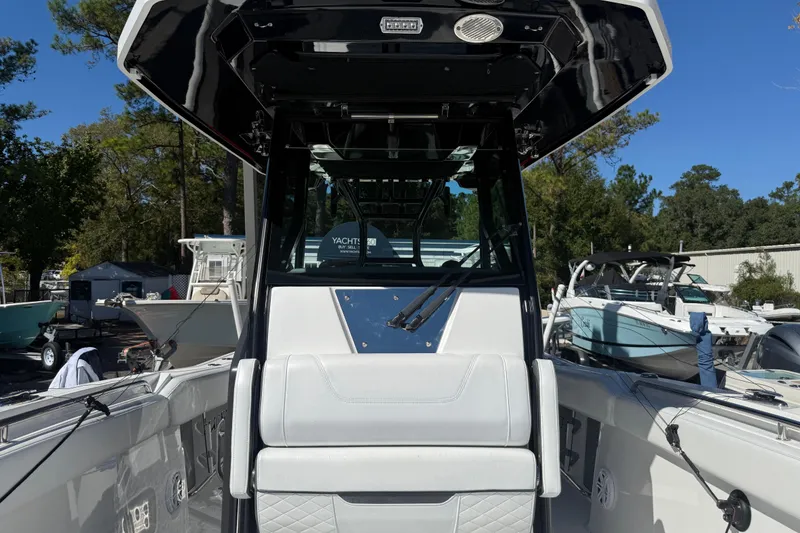 Slide: The Image of 2022 Blackfin 272 CC boat interior with seating and console, docked outdoors. - 7
