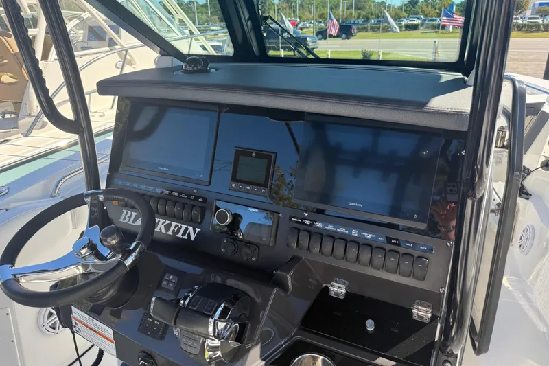 Slide: The Image of 2022 Blackfin 272 CC boat dashboard with steering wheel and navigation screens. - 8