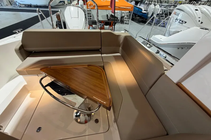 Slide: The Image of Luxurious seating area on 2025 Nimbus Weekender 9 boat with wooden table. - 13