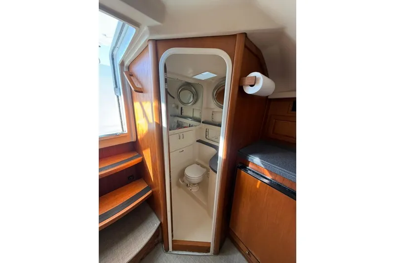 Slide: The Image of 2001 Luhrs Tournament 320 Open boat interior with compact bathroom and wooden cabinetry. - 11
