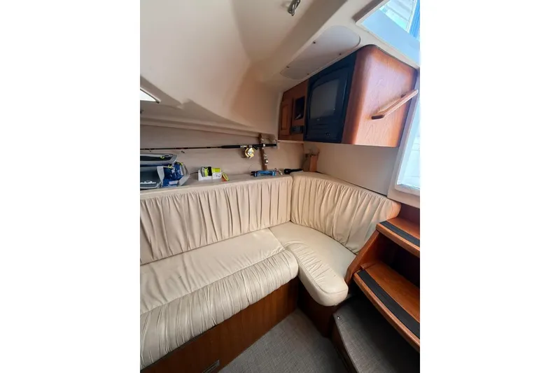 Slide: The Image of 2001 Luhrs Tournament 320 Open cabin interior with beige seating and wooden cabinetry. - 8