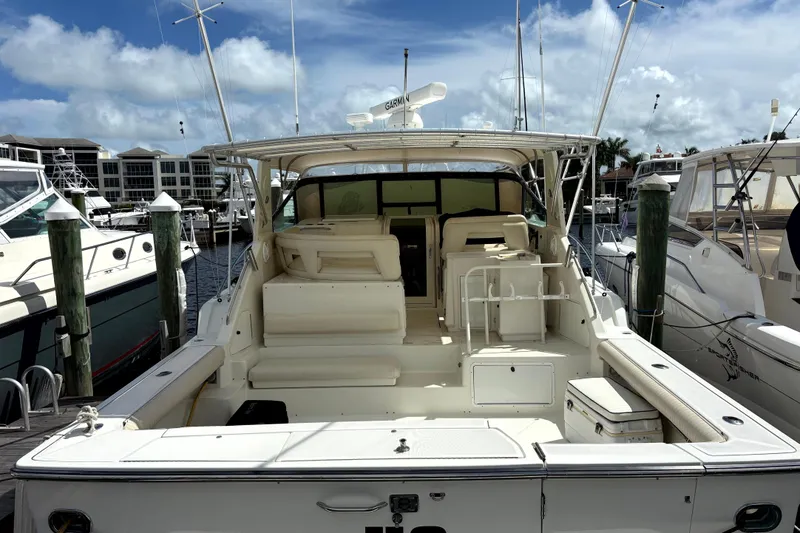 Slide: The Image of 1993 Tiara Yachts 43 Open docked at marina, showcasing spacious deck and seating area. - 3