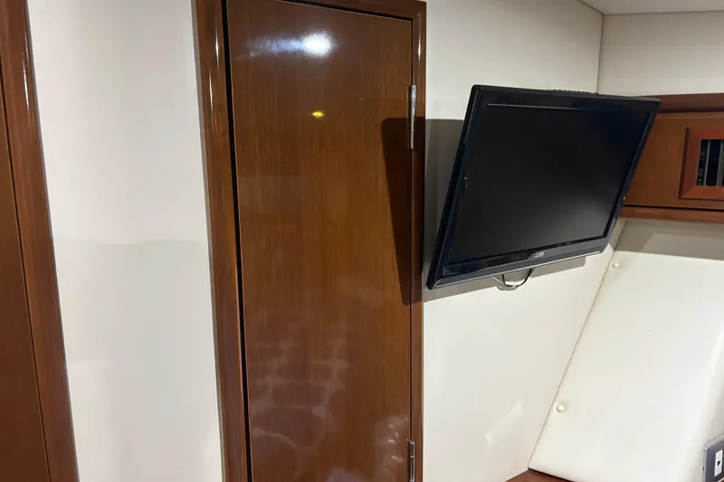 Slide: The Image of Interior of 2007 Carver 42 Super Sport with mounted TV and wooden cabinet. - 11