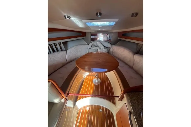 Slide: The Image of Interior of 2005 Chaparral 290 Signature boat with cozy seating and wooden table. - 18