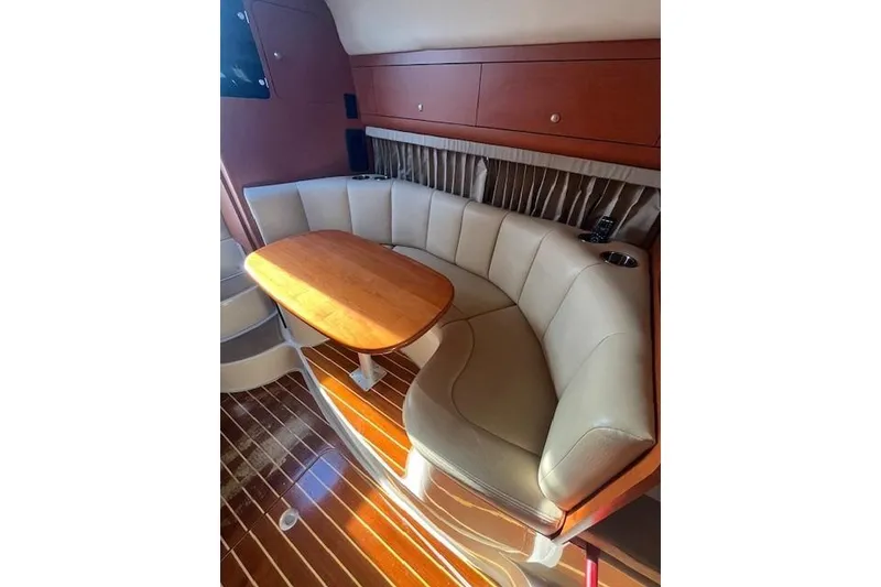 Slide: The Image of 2005 Chaparral 290 Signature boat interior with curved seating and wooden table. - 19