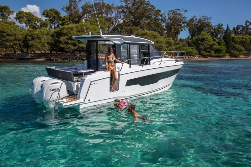 The Image of 2026 Jeanneau NC 895 Series 2 boat on clear water with people swimming nearby. - 0