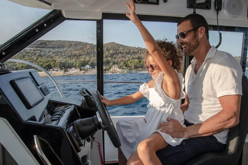 Slide: The Image of Father and daughter enjoying a ride on a 2026 Jeanneau NC 895 Series 2 boat. - 12