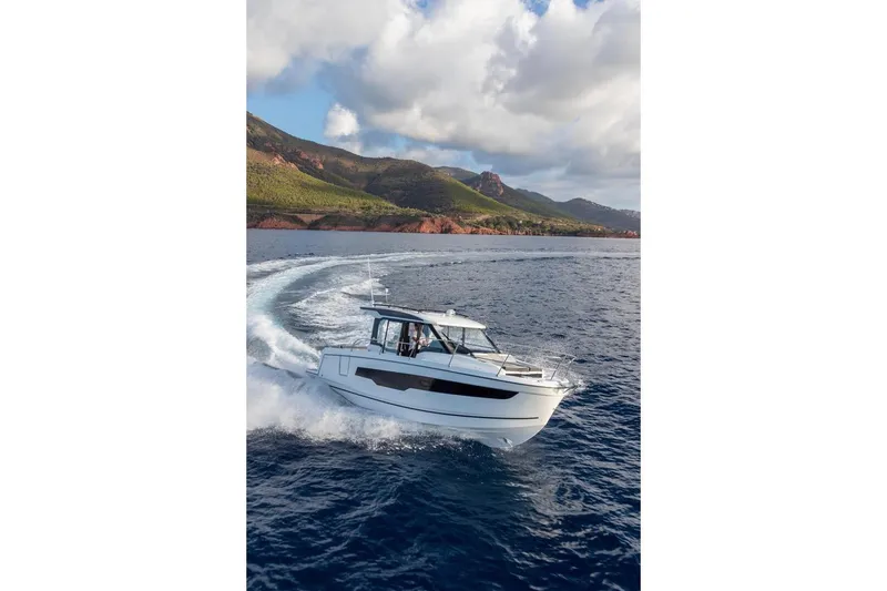 Slide: The Image of 2026 Jeanneau NC 895 Series 2 cruising on open water with scenic mountain backdrop. - 3