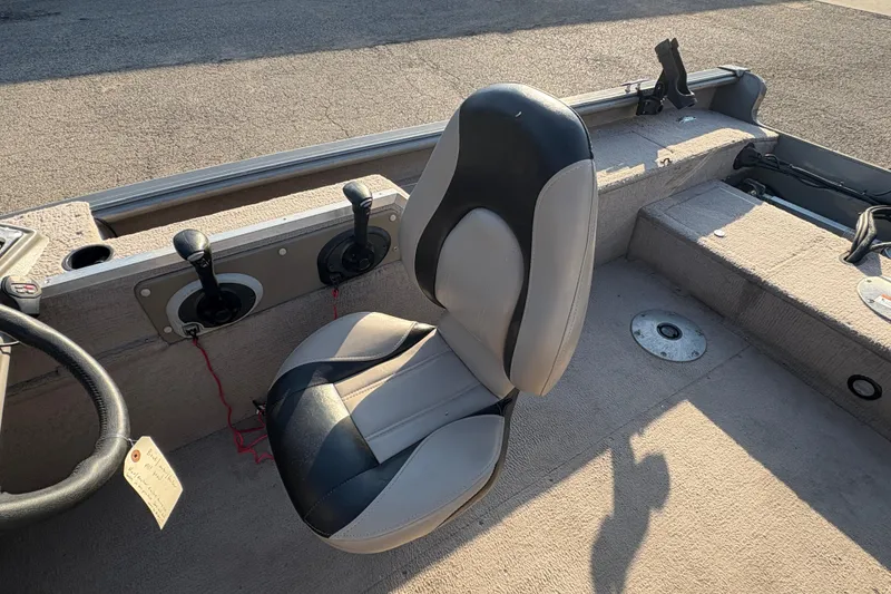 Slide: The Image of 2004 Lund 1800 Explorer SS boat interior with seat and control levers. - 17