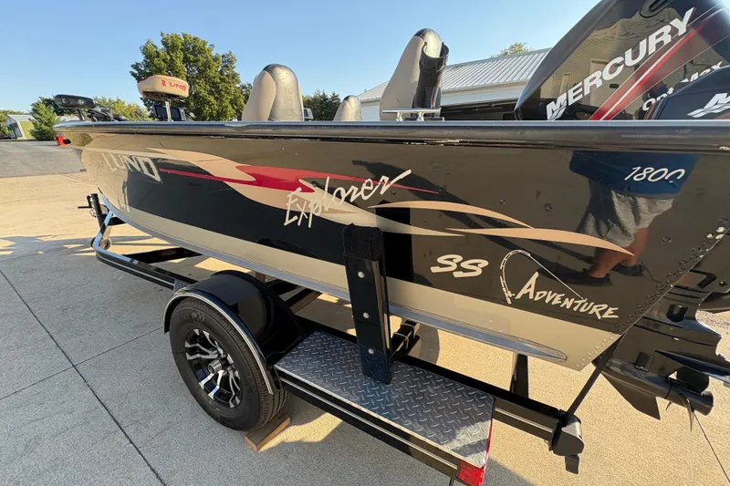 Slide: The Image of 2004 Lund 1800 Explorer SS boat on trailer, featuring sleek design and Mercury engine. - 34