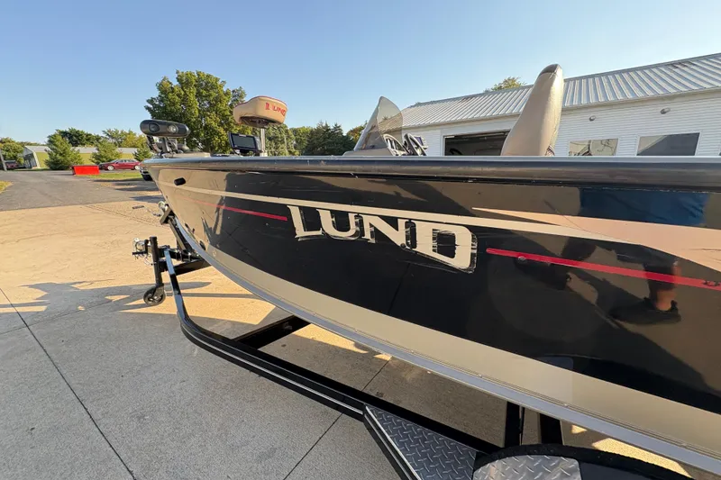 Slide: The Image of 2004 Lund 1800 Explorer SS boat on trailer, parked outdoors in sunny setting. - 35