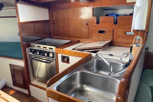 Slide: The Image of 1975 Tartan 41 yacht interior with kitchen, stove, and sink. - 13