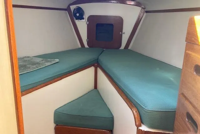 Slide: The Image of 1975 Tartan 41 sailboat interior with teal cushions and wooden accents. - 15