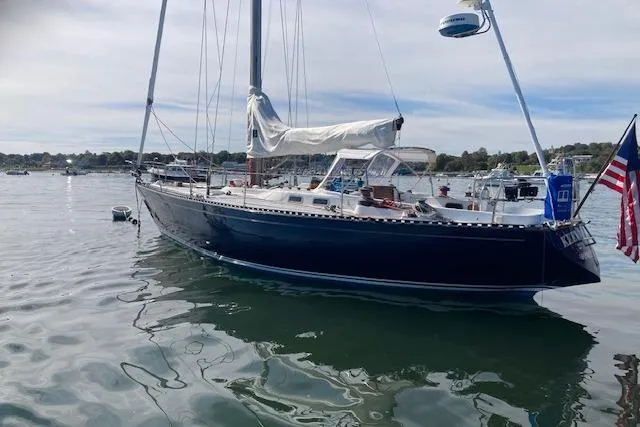 Slide: The Image of 1975 Tartan 41 sailboat with American flag, anchored in calm waters. - 2