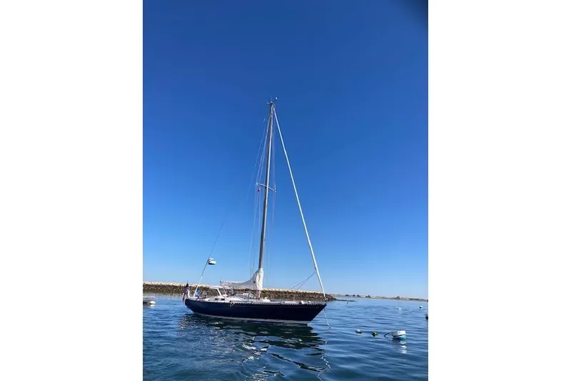 Slide: The Image of 1975 Tartan 41 sailboat on calm water under clear blue sky. - 3