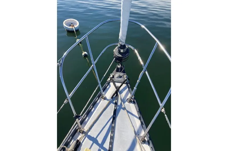 Slide: The Image of Bow of 1975 Tartan 41 sailboat with stainless steel railings on calm water. - 7